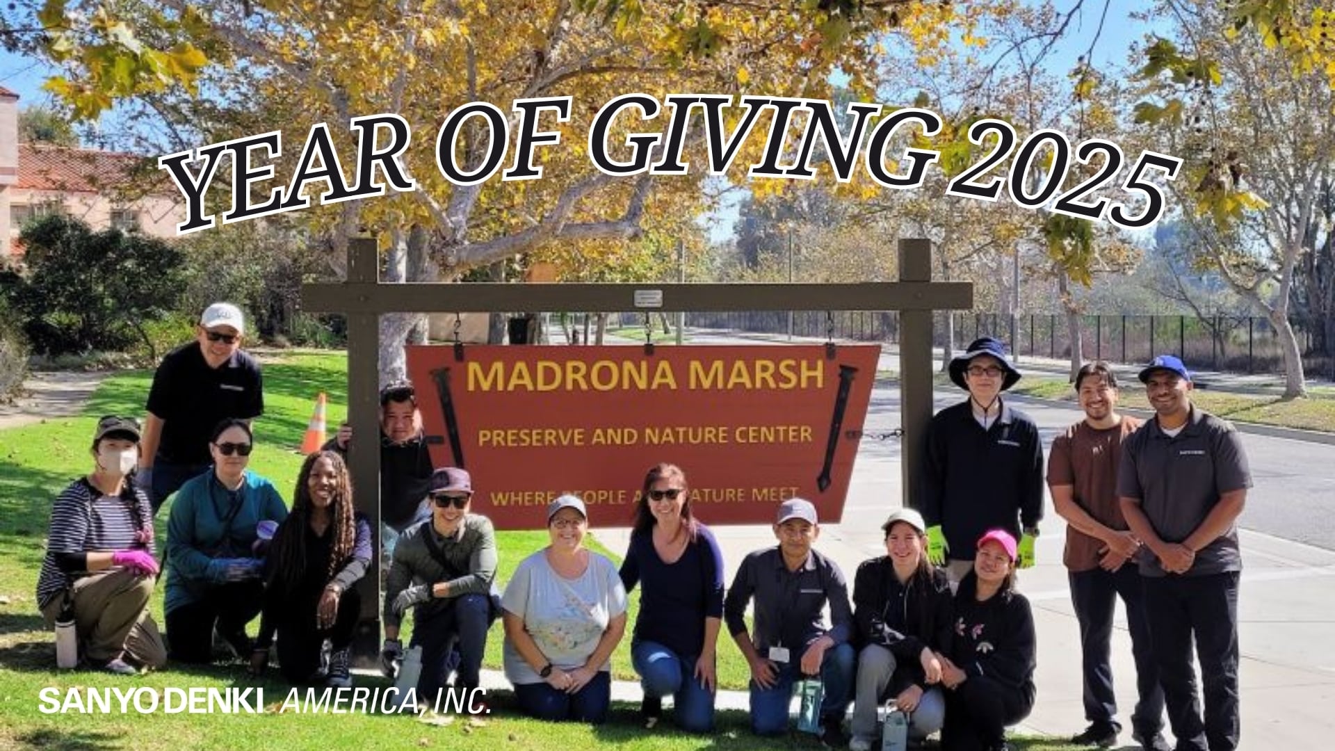 Group of SANYO DENKI America employees pose outdoors in front of the “Madrona Marsh Preserve and Nature Center” sign